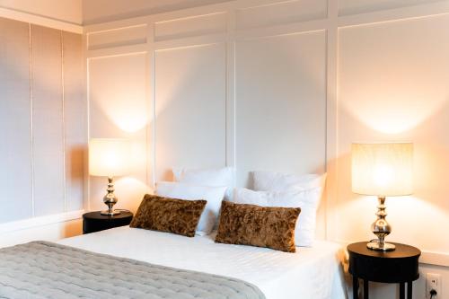 a bedroom with a white bed with two lamps at Château de Taulignan in Saint-Marcellin-lès-Vaison
