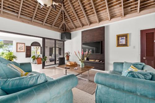 a living room with two blue couches and a table at Forever Summer Gorgeous 4BDR Villa with Pool Private Chef in Runaway Bay