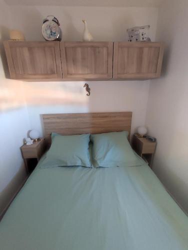 - une chambre avec un lit doté d'oreillers et de placards bleus dans l'établissement Charmant appartement à Sainte Marie la mer (66470), à Sainte-Marie-Plage