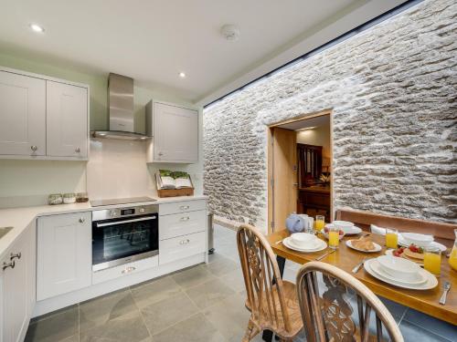 a kitchen with a table and a stone wall at 2 Bed in Helmsley G0131 in Helmsley