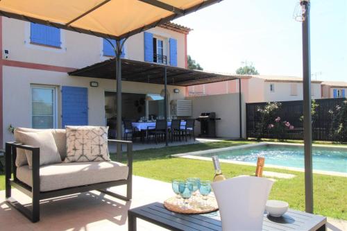 - une terrasse avec une chaise et un parasol à côté de la piscine dans l'établissement Gridelaide 24 - A Grimaud dans le Golfe de St Tropez - Villa avec piscine privative à proximité de la plage, à Grimaud