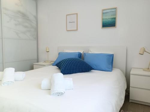 a bedroom with a white bed with blue pillows at Lavrinha in Lavra