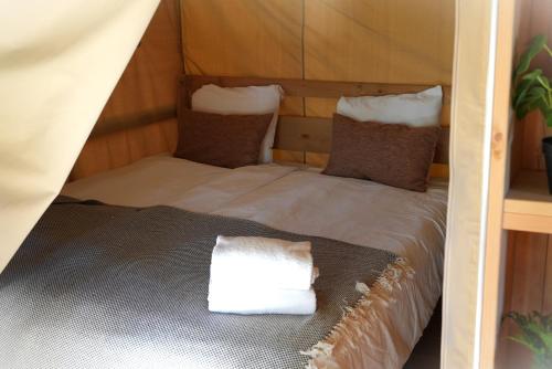 a bed in a tent with a pillow on it at Norrqvarn Hotel & Resort by Vänerport in Lyrestad