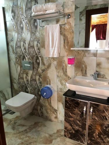 a bathroom with a toilet and a sink at Loft Suit Apart Otel in İskenderun