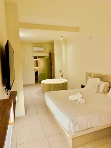 a bedroom with a bed and a sink and a tub at Reina Victoria Velázquez in Alicante