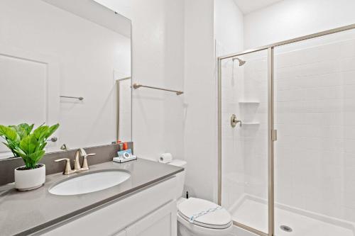 a white bathroom with a sink and a shower at Special 4bedroom TH w-private pool next to Disney in Kissimmee
