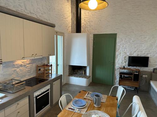 a kitchen with a table and a green door at Serenity Hill in Kithnos