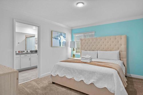 Un dormitorio con una cama grande con una pared azul. en Spacious 5BR Home with Pool Near Top Attractions, en Kissimmee
