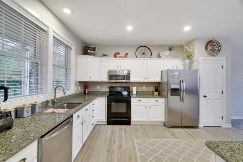 a kitchen with white cabinets and a stainless steel refrigerator at The Nest at Pinecrest by AvantStay Spacious Deck Game Room Fire Pit in Pocono Pines