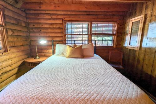a bedroom with a bed in a log cabin at Hickory Cabin by AvantStay Firepit Hot Tub Game Room Great Location in Palmerton