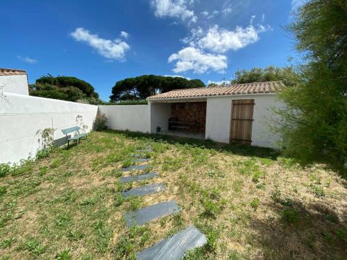 ル・ボワ・プラージュ・アン・レにあるMaison Les Tamarisの庭のベンチ付白い家