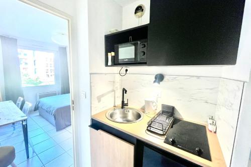- une cuisine avec évier et un lit dans une chambre dans l'établissement Beautiful studio for 2 in downtown, à Aix-en-Provence