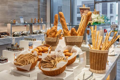 a group of baskets of bread and pastries on a table at Durrat Jalmouda Hotel in Al Jubail
