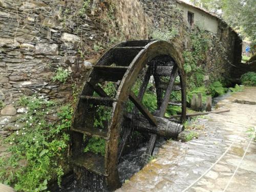 São Pedro de AlvaにあるCasa do Rio Alvaの石壁の隣にある錆びた古い物体