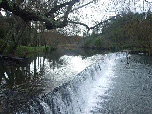 a waterfall in the middle of a river at Casa do Rio Alva in São Pedro de Alva