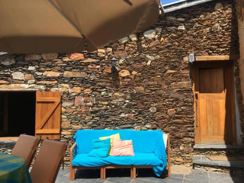 a blue chair sitting in front of a stone building at Casa do Rio Alva in São Pedro de Alva