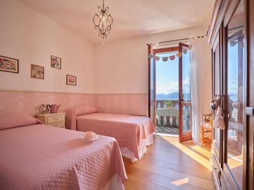 a bedroom with two beds and a balcony at La Casa di Mia - country house in Torri del Benaco