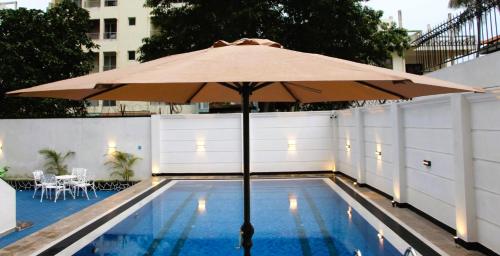 a large umbrella sitting next to a swimming pool at The Beach Villa in Mount Lavinia
