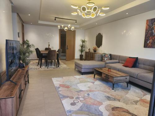 a living room with a couch and a tv and a table at Casablanca Marina by Saloua in Casablanca