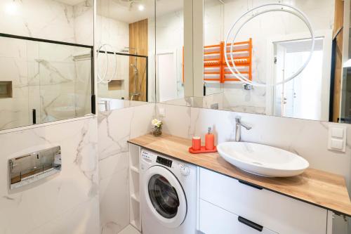 a bathroom with a washing machine and a sink at Czarna Perła Hel in Hel