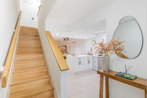 a staircase in a white kitchen with a mirror at Gorgeous Beach Front Condo Near Flagler Ave - 701 in New Smyrna Beach