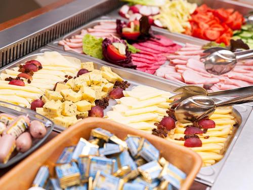 een buffet van verschillende soorten kaas en vlees bij Goldvilla Apartman in Zalakaros