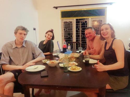 a group of people sitting around a table at Happy Three Holiday Homes in Hikkaduwa