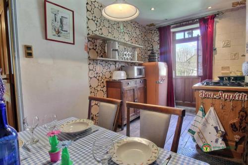 une cuisine avec une table et un réfrigérateur dans l'établissement L'étape de Brocéliande, à Josselin