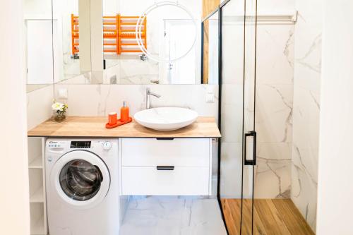 a bathroom with a washing machine and a sink at Czarna Perła Hel in Hel