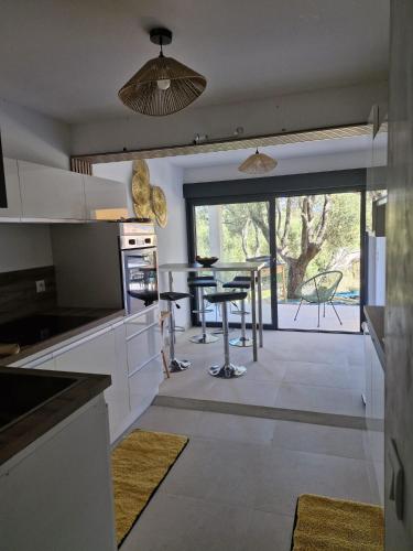 une cuisine avec une table et une salle à manger dans l'établissement Maison Rez-de-jardin 80 m de la plage, à Serra-di-Ferro