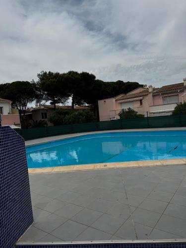 une grande piscine bleue en face de certaines maisons dans l'établissement Furnished 2-room apartment with terrace, au Cap d'Agde