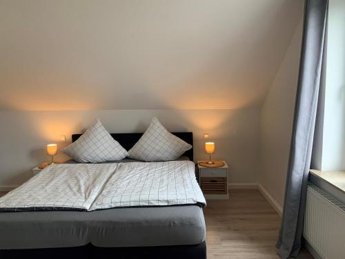 a bedroom with a bed with two lamps on tables at Katharina Boardinghouse in Osnabrück