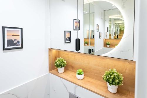 a bathroom with two potted plants and a mirror at Czarna Perła Hel in Hel