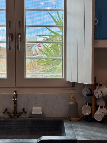a kitchen with a sink and a window over a kitchen counter at Aloni House in Triandáros