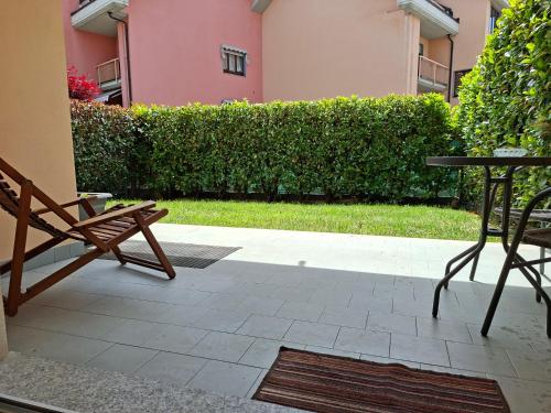 a patio with a bench and a table and a hedge at BG House - appartamento con giardino e garage privato in Cuneo