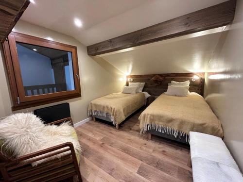 une chambre avec deux lits et un miroir dans l'établissement GRAVACHES 3 Appt 6 pers, centre, pistes, à La Clusaz