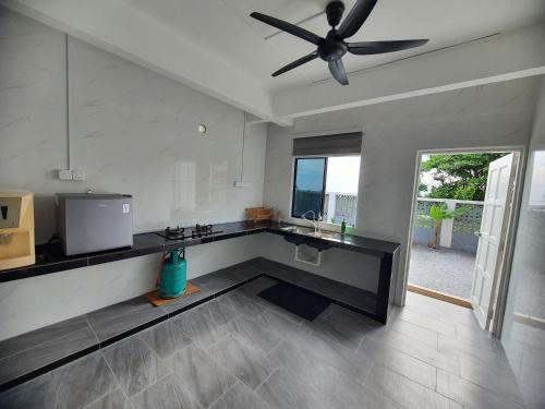 a kitchen with a ceiling fan and a counter at Nuri Homestay Rusila 2 in Kuala Terengganu
