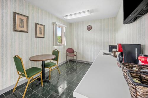 een kamer met een tafel en stoelen en een aanrecht bij Americas Best Value Inn - Roxboro in Roxboro