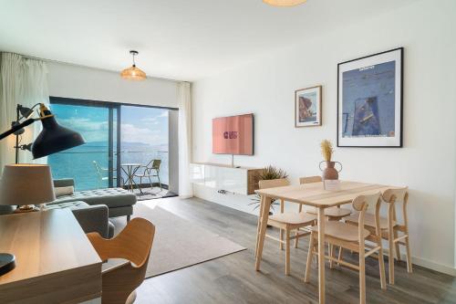 un soggiorno con tavolo e un soggiorno con vista. di GuestReady - Endless Ocean Views a Santa Cruz