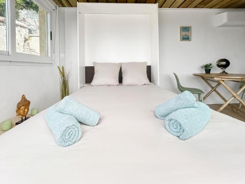 a white bedroom with a large bed with blue pillows at Eco lodge, vue exceptionnelle! in Duclair