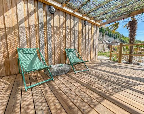 two green lawn chairs sitting on a wooden deck at Eco lodge, vue exceptionnelle! in Duclair