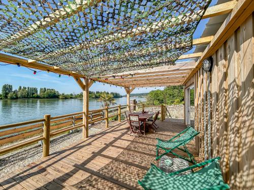 a pergola with chairs and a table on a patio at Eco lodge, vue exceptionnelle! in Duclair