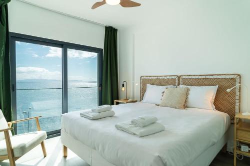a bedroom with a large white bed with a large window at GuestReady - Endless Ocean Views in Santa Cruz