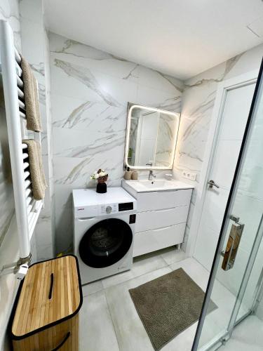 a bathroom with a sink and a washing machine at Apartman Leoni 1 linea in Salou
