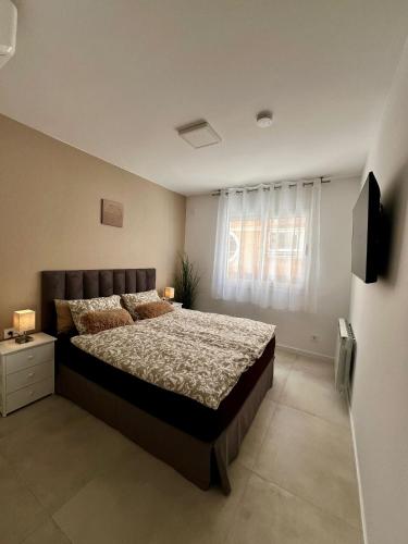 a bedroom with a large bed and a window at Apartman Leoni 1 linea in Salou