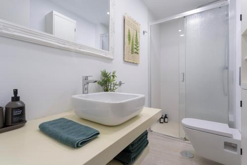 ein weißes Badezimmer mit Waschbecken und Toilette in der Unterkunft Calle Agua Center&Parking&Woodland in Málaga