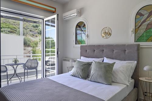 a bedroom with a bed and a balcony with a table at Maio Seaview & Sunset Stay in Kremasti Rhodes in Kremasti