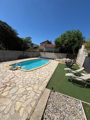 une piscine avec des chaises longues et un espace non intentionnel dans l'établissement Villa spacieuse avec piscine privée à Montpellier, à Montpellier