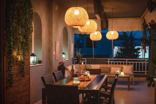 a dining room with a table and chairs and chandeliers at Maio Seaview & Sunset Stay in Kremasti Rhodes in Kremasti