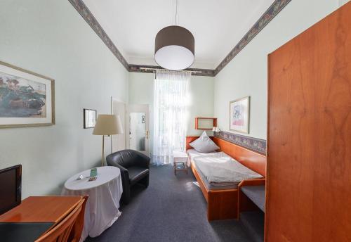 a hotel room with a bed and a table at Pension Am Sültebrunnen in Bad Oeynhausen